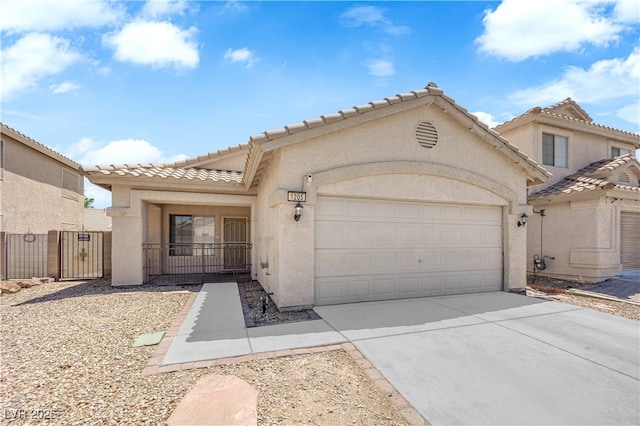 1205 Boulder Shore Ave, North Las Vegas, NV 89081 - view of front of house featuring an attached garage, stucco siding, driveway, a tiled roof, and a gate