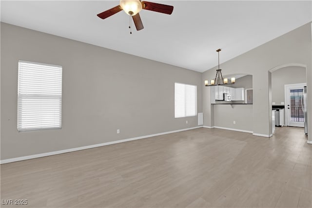1205 Boulder Shore Ave, North Las Vegas, NV 89081 - unfurnished room with vaulted ceiling, ceiling fan, arched walkways, light wood-style flooring, and a chandelier