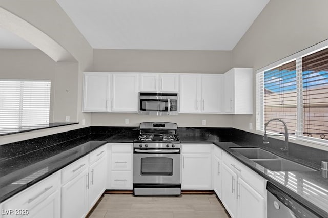 1205 Boulder Shore Ave, North Las Vegas, NV 89081 - kitchen with stainless steel appliances, white cabinets, and arched walkways