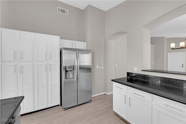 1205 Boulder Shore Ave, North Las Vegas, NV 89081 - kitchen featuring stainless steel fridge with ice dispenser, white cabinets, light wood-style flooring, and arched walkways