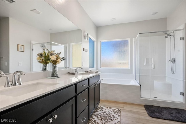 7009 Judith River St, North Las Vegas, NV 89084 - bathroom featuring a stall shower, a bath, wood finished floors, and double vanity