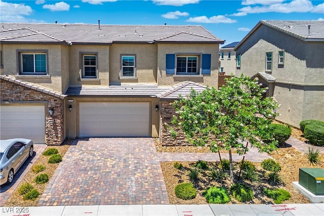 7009 Judith River St, North Las Vegas, NV 89084 - view of property featuring a tiled roof, an attached garage, stucco siding, and decorative driveway