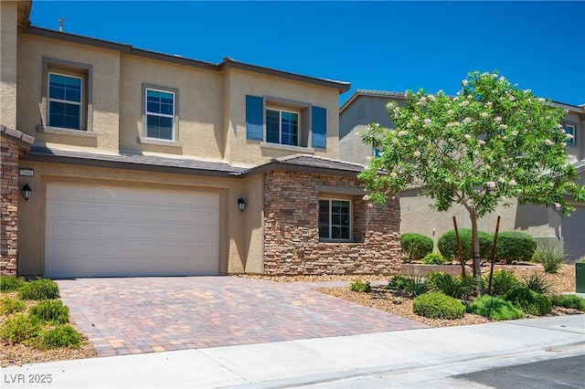 7009 Judith River St, North Las Vegas, NV 89084 - view of front of home featuring stucco siding, a garage, stone siding, and decorative driveway