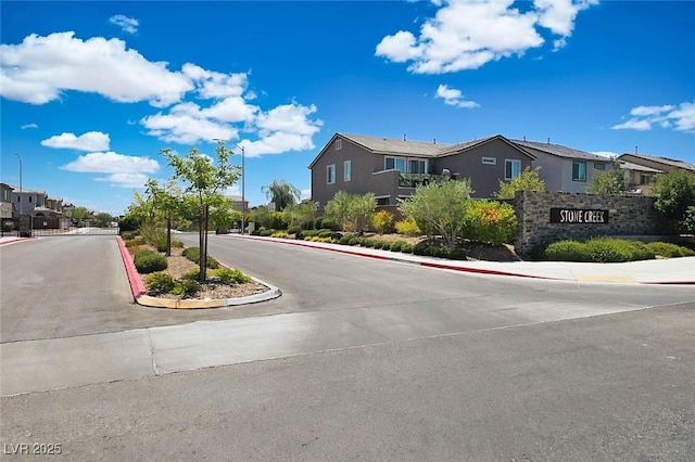 7009 Judith River St, North Las Vegas, NV 89084 - view of asphalt street with street lights, a residential view, and sidewalks