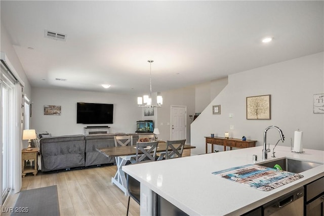 7009 Judith River St, North Las Vegas, NV 89084 - kitchen featuring light wood-style floors, light countertops, dishwashing machine, pendant lighting, and recessed lighting