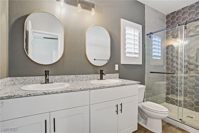 7546 Cooks Meadow St, North Las Vegas, NV 89084 - bathroom featuring double vanity, a shower stall, and wood finished floors