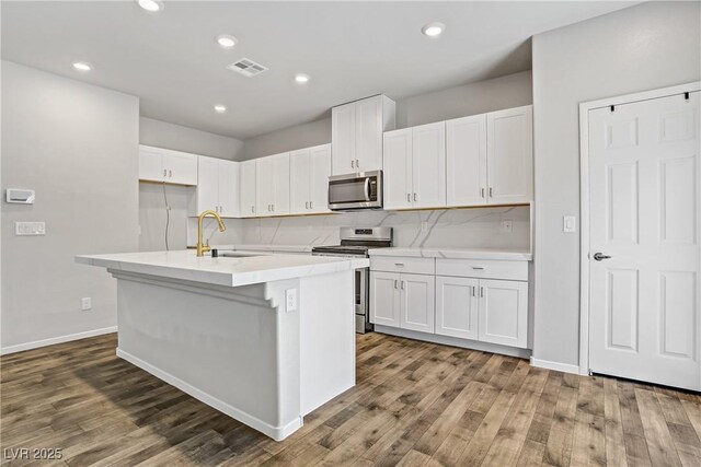 7546 Cooks Meadow St, North Las Vegas, NV 89084 - kitchen with stainless steel appliances, wood finished floors, white cabinets, and recessed lighting