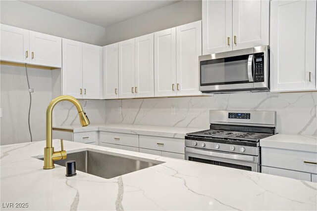 7546 Cooks Meadow St, North Las Vegas, NV 89084 - kitchen with stainless steel appliances, white cabinets, decorative backsplash, and light stone counters