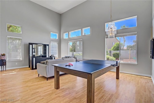 229 Wellspring Ave, Las Vegas, NV 89183 - game room with a towering ceiling, light wood finished floors, and a chandelier