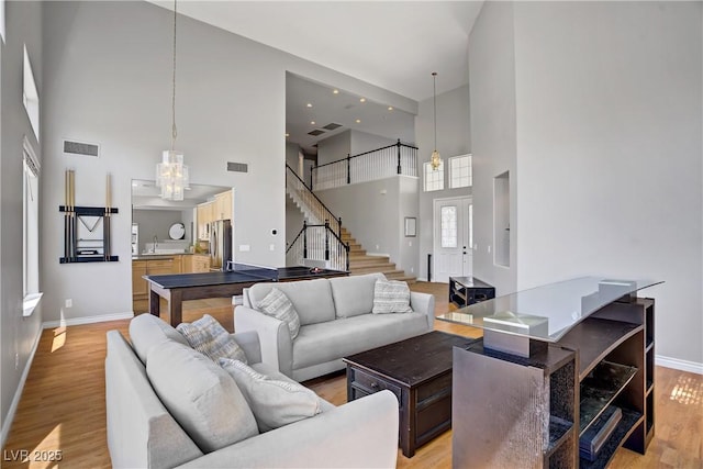 229 Wellspring Ave, Las Vegas, NV 89183 - living room with a high ceiling, light wood-type flooring, a chandelier, and stairway