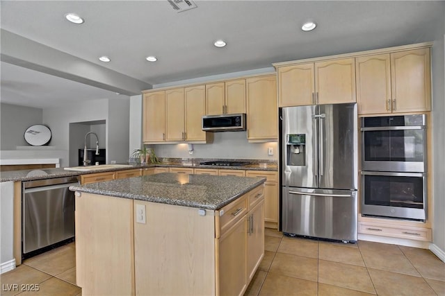229 Wellspring Ave, Las Vegas, NV 89183 - kitchen featuring stainless steel appliances, light brown cabinets, dark stone counters, light tile patterned floors, and a center island