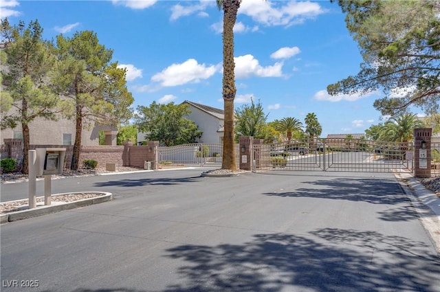 229 Wellspring Ave, Las Vegas, NV 89183 - view of asphalt road with a gate, curbs, and a gated entry
