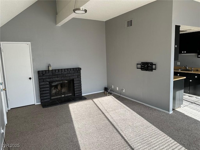 4241 Gannet Cir Unit 202, Las Vegas, NV 89103 - unfurnished living room featuring carpet floors, a brick fireplace, and vaulted ceiling