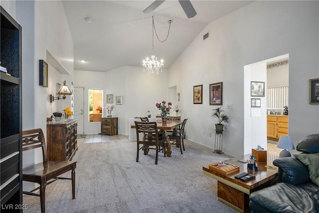 2441 Banora Point Dr, Las Vegas, NV 89134 - dining room with high vaulted ceiling, a ceiling fan, light colored carpet, and a chandelier