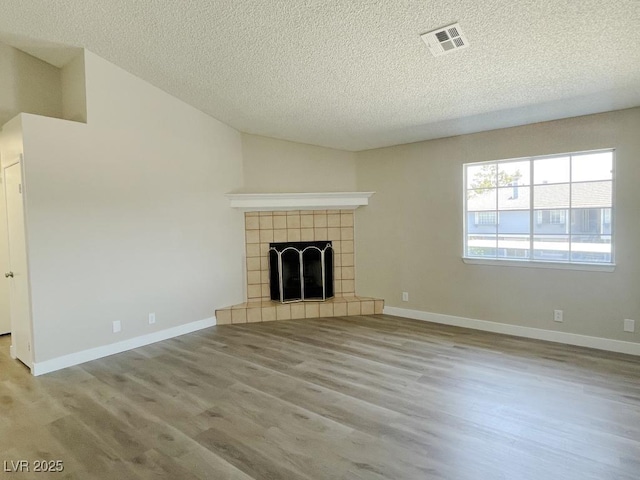 5385 Shake Ct Unit 203, Las Vegas, NV 89122 - unfurnished living room featuring a textured ceiling, wood finished floors, a fireplace, and lofted ceiling