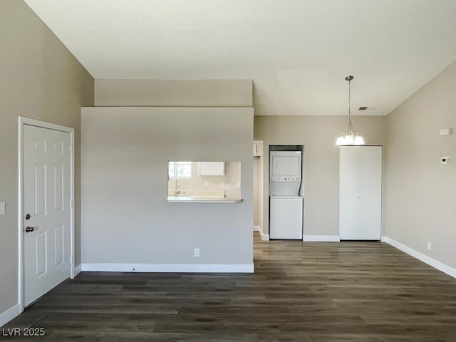 5385 Shake Ct Unit 203, Las Vegas, NV 89122 - unfurnished room with estacked washer and dryer, dark wood finished floors, and a chandelier