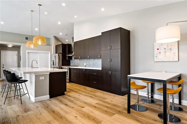 3890 Quadrel St, Las Vegas, NV 89129 - kitchen featuring stainless steel appliances, light wood-style flooring, light countertops, a kitchen island with sink, and recessed lighting