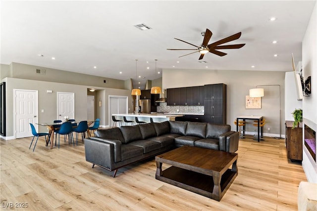 3890 Quadrel St, Las Vegas, NV 89129 - living room featuring lofted ceiling, a ceiling fan, recessed lighting, light wood-style flooring, and a multi sided fireplace