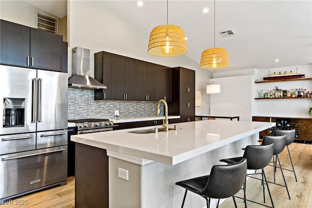 3890 Quadrel St, Las Vegas, NV 89129 - kitchen featuring high quality appliances, wall chimney range hood, light wood-style flooring, tasteful backsplash, and high vaulted ceiling