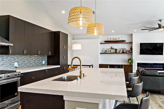 3890 Quadrel St, Las Vegas, NV 89129 - kitchen with stainless steel gas stove, open floor plan, light countertops, a ceiling fan, and a center island with sink