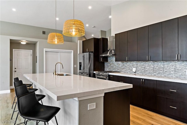 3890 Quadrel St, Las Vegas, NV 89129 - kitchen with appliances with stainless steel finishes, backsplash, an island with sink, wall chimney range hood, and recessed lighting