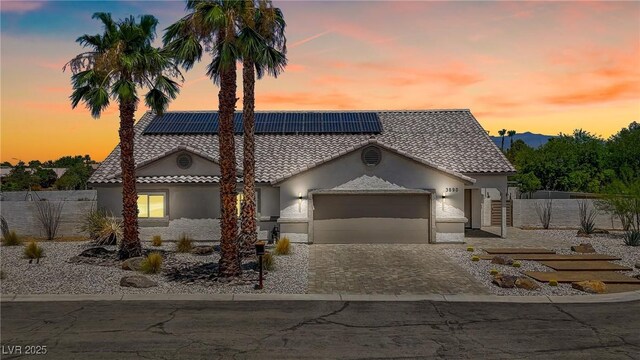 3890 Quadrel St, Las Vegas, NV 89129 - mediterranean / spanish-style home with a tile roof, stucco siding, an attached garage, and roof mounted solar panels
