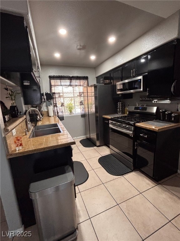 1600 N Torrey Pines Dr Unit 101, Las Vegas, NV 89108 - kitchen with appliances with stainless steel finishes, dark cabinetry, light tile patterned floors, recessed lighting, and light countertops