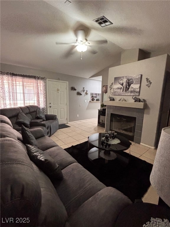 1600 N Torrey Pines Dr Unit 101, Las Vegas, NV 89108 - living room featuring a ceiling fan, a textured ceiling, a fireplace, light tile patterned floors, and lofted ceiling