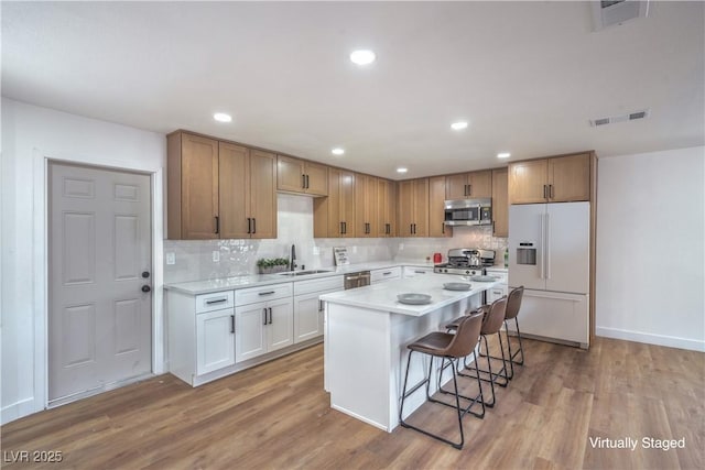 5279 Consul Ave, Las Vegas, NV 89142 - kitchen featuring stainless steel appliances, light wood finished floors, a breakfast bar, backsplash, and recessed lighting