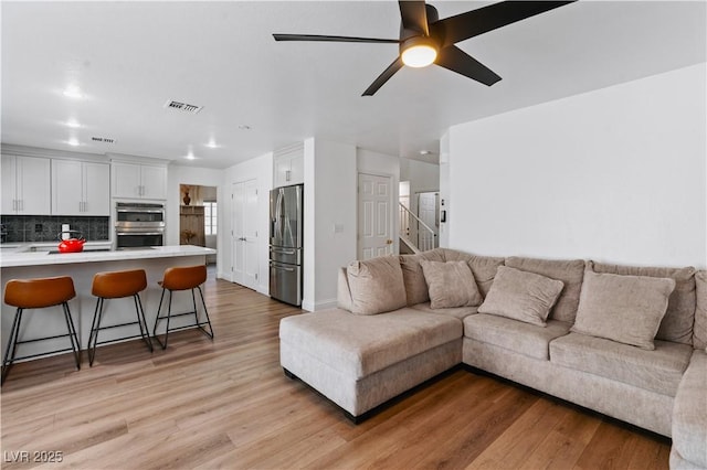 4305 Threshold Ct, North Las Vegas, NV 89032 - living area with light wood-type flooring, ceiling fan, and stairs