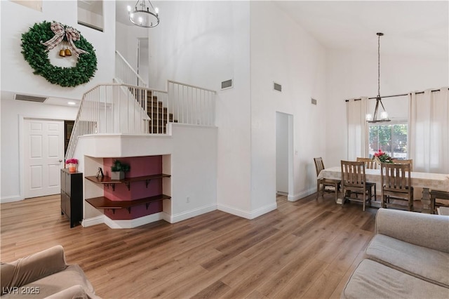 4305 Threshold Ct, North Las Vegas, NV 89032 - living room featuring a chandelier, high vaulted ceiling, stairs, and wood finished floors