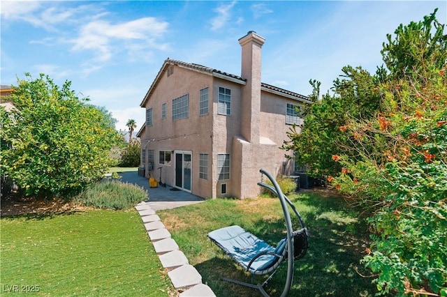 4305 Threshold Ct, North Las Vegas, NV 89032 - back of house with stucco siding, a chimney, a lawn, and a patio