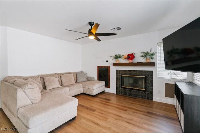4305 Threshold Ct, North Las Vegas, NV 89032 - living room featuring light wood-style floors, ceiling fan, and a fireplace