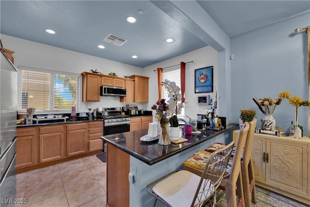 4650 Ranch House Rd Unit 64, North Las Vegas, NV 89031 - kitchen with appliances with stainless steel finishes, a kitchen breakfast bar, a peninsula, recessed lighting, and brown cabinetry