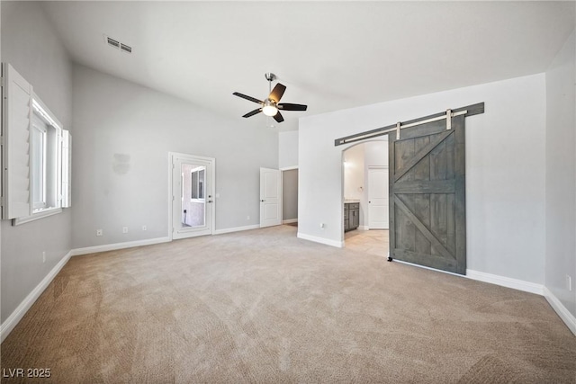 5210 E Chasemoor St, Pahrump, NV 89061 - unfurnished bedroom featuring a barn door, light carpet, and ensuite bathroom