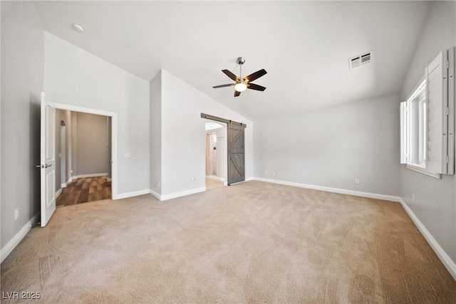 5210 E Chasemoor St, Pahrump, NV 89061 - unfurnished bedroom with lofted ceiling, light colored carpet, a barn door, and a ceiling fan