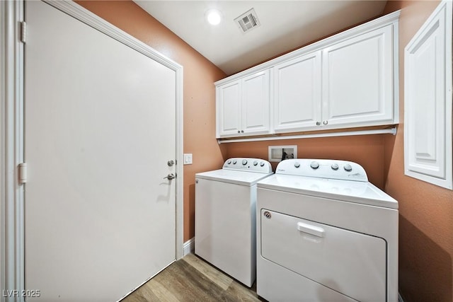 5210 E Chasemoor St, Pahrump, NV 89061 - laundry room featuring washing machine and dryer, cabinet space, and light wood-style flooring