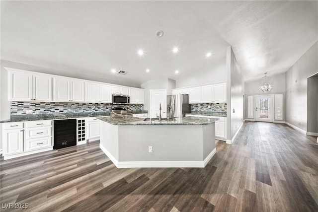 5210 E Chasemoor St, Pahrump, NV 89061 - kitchen with appliances with stainless steel finishes, wine cooler, tasteful backsplash, lofted ceiling, and a kitchen island with sink