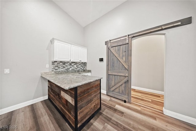 5210 E Chasemoor St, Pahrump, NV 89061 - bar featuring a barn door, high vaulted ceiling, light wood-type flooring, and tasteful backsplash