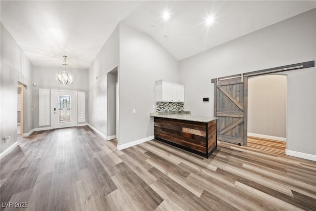 5210 E Chasemoor St, Pahrump, NV 89061 - entryway featuring a barn door, high vaulted ceiling, a chandelier, and light wood-type flooring