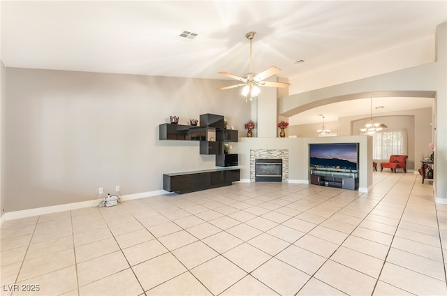 1442 Big Tree Ave, North Las Vegas, NV 89031 - unfurnished living room with a tiled fireplace, light tile patterned floors, a chandelier, arched walkways, and vaulted ceiling