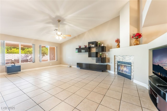 1442 Big Tree Ave, North Las Vegas, NV 89031 - unfurnished living room with light tile patterned floors, a ceiling fan, high vaulted ceiling, and a tiled fireplace