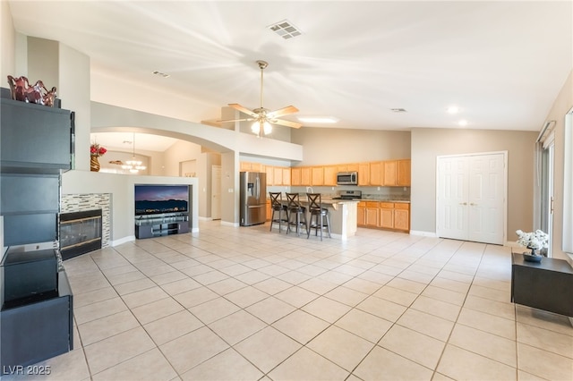 1442 Big Tree Ave, North Las Vegas, NV 89031 - living area with lofted ceiling, a ceiling fan, light tile patterned floors, a fireplace, and arched walkways