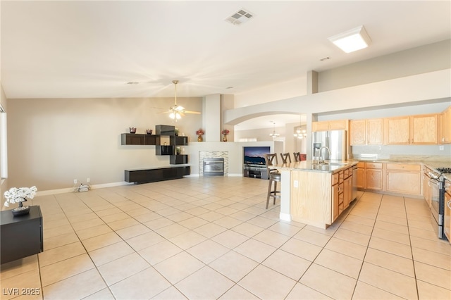 1442 Big Tree Ave, North Las Vegas, NV 89031 - kitchen featuring light brown cabinetry, open floor plan, ceiling fan, and light tile patterned floors