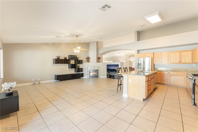 1442 Big Tree Ave, North Las Vegas, NV 89031 - kitchen featuring light brown cabinets, open floor plan, ceiling fan, and light tile patterned floors