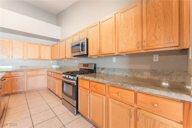 1442 Big Tree Ave, North Las Vegas, NV 89031 - kitchen with appliances with stainless steel finishes, light brown cabinets, light tile patterned flooring, and light stone countertops