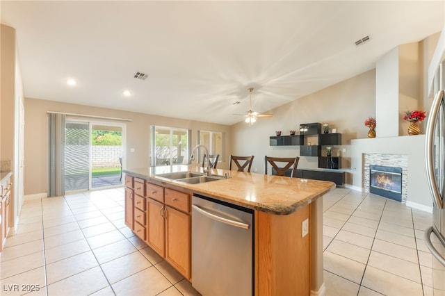 1442 Big Tree Ave, North Las Vegas, NV 89031 - kitchen featuring stainless steel dishwasher, light tile patterned floors, a kitchen island with sink, light stone counters, and vaulted ceiling