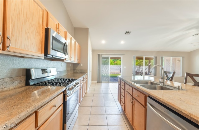 1442 Big Tree Ave, North Las Vegas, NV 89031 - kitchen featuring stainless steel appliances, light tile patterned floors, light brown cabinets, light stone counters, and recessed lighting