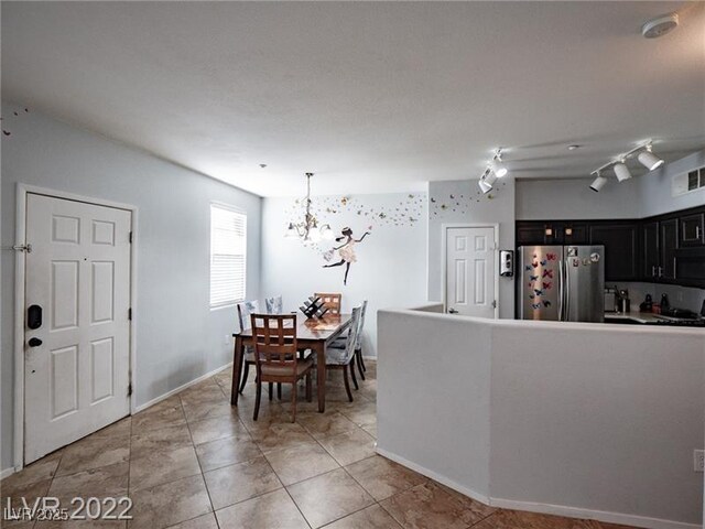 50 Aura De Blanco St Unit 13202, Henderson, NV 89074 - kitchen with freestanding refrigerator, a chandelier, dark cabinetry, black microwave, and light tile patterned flooring