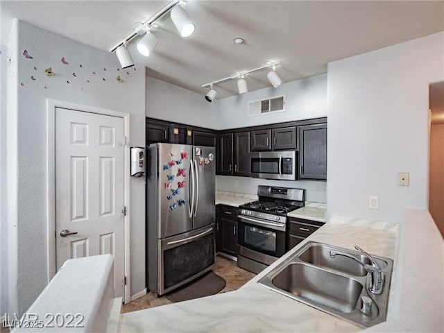 50 Aura De Blanco St Unit 13202, Henderson, NV 89074 - kitchen with stainless steel appliances, rail lighting, dark cabinetry, and light tile patterned floors